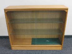 A teak effect sliding glass door bookcase