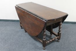 A Georgian oak gate leg table with peg top fitted a drawer