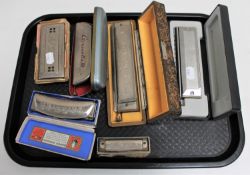 A tray of six mouth organs - Hohner chromonica III, Chrometta I0 and three others and a slide.