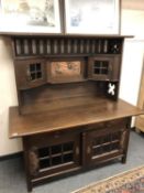 An oak Arts and Crafts sideboard with copper detail and inset panel,