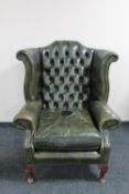 A green buttoned leather Chesterfield wingback armchair