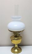 An antique brass Aladdin oil lamp with glass shade and chimney