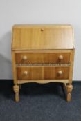 A mid 20th century oak writing bureau with pine handles