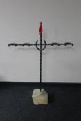 A wrought iron horse shoe boot stand mounted on a piece of sandstone