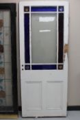 An antique painted vestibule door with stained leaded glass panels