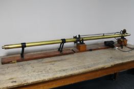 An early 20th century solid brass 6' electric light beam measuring telescope on mahogany base