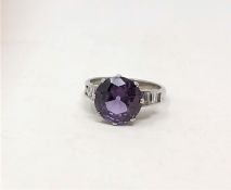 An 18ct gold ring, possibly Alexandrite, with baguette-cut diamond set shoulders,