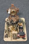 A tray of ornate gilt metal mantel clock, brass cannons, tins, plated car,