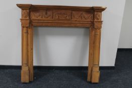 A heavily carved pine fire surround CONDITION REPORT: 124cm high by 140cm wide by