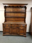 A Georgian style oak dresser fitted with drawers and cupboards,