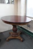 An antique oval pedestal dining table