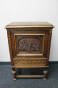 A continental carved oak panel door cabinet fitted with a drawer on raised legs