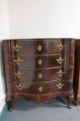 An antique serpentine fronted four drawer chest with metal handles