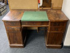 An antique mahogany twin pedestal writing desk fitted with five drawers and cupboards with green
