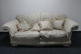 A two seater settee with loose cushions upholstered in a classical print