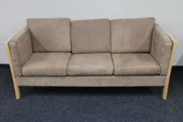A Danish wooden framed three seater settee in suede upholstery