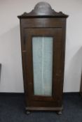 A 20th century glazed sentry door cabinet on bun feet