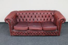 A red buttoned leather three seater Chesterfield settee
