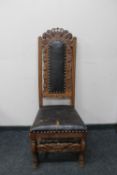 An antique carved oak leather upholstered hall chair