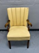 A walnut Art Deco style armchair upholstered in a cream fabric