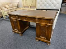 An early twentieth century oak twin pedestal desk on bun feet