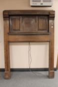 An Edwardian linen fold oak fire surround