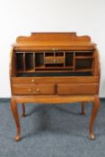 An Eastern hardwood roll top bureau