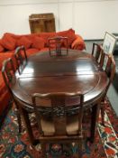 A Chinese hardwood extending dining table and matching set of six chairs.