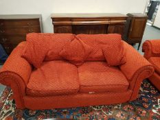 A contemporary four seater and two seater settees upholstered in burnt rust coloured fabric,