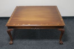 A square mahogany coffee table on claw and ball feet