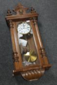 An antique mahogany cased wall clock with pendulum,