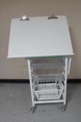 A metal medical trolley with adjustable top,