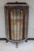An antique mahogany D-shaped display cabinet on claw and ball feet