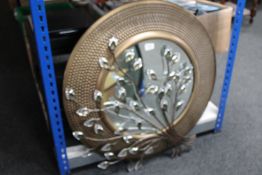 A metal framed mirror and piece of metal wall art