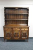 A carved oak triple door kitchen dresser