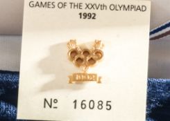 A Gold Coloured Lapel Badge depicting the Olympic Rings and the Date 1992 Commemorating “The Games