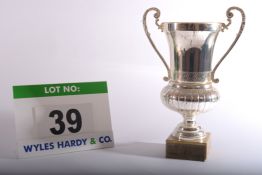 A Silver Coloured Trophy Cup in the form of a Ewer with Two Handles on a Composite Marble Plinth