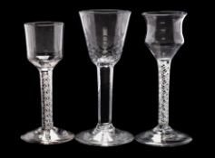 Three English wine glasses: one with hammered rounded funnel shaped bowl on a straight stem and
