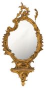 WITHDRAWN A 19th Century carved gilt gesso mirror of cartouche outline:, the plate with rocaille,
