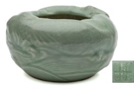 A Chinese celadon brush washer: of circular form moulded with two carp swimming amongst waves,
