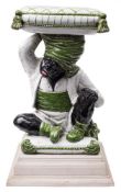 A pair of Continental glazed earthenware garden seats: each in the form of a blackamoor child