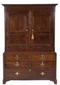 An 18th Century oak side cupboard:, the upper part with a moulded cornice,