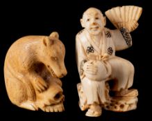 A Japanese carved netsuke: of a seated peasant holding a fan in one hand and a sack in the other,