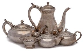 An Indian silver five piece tea & coffee service: the coffee and teapot with ceramic insulators to