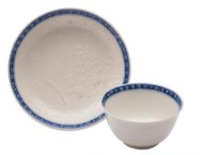 A Chinese blue and white soft-paste teabowl and saucer: thinly potted and decorated in white relief