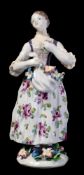 A Bow figure of a flower seller: a bunch of flowers gathered in her apron and holding a posy in her