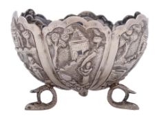 A South East Asian silver dish: of lobed circular form, with embossed decoration of village scenes,