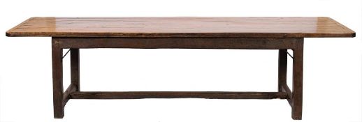 An oak dining table of refectory type:, the rectangular plank top with rounded corners,
