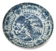 A large Chinese Swatow blue and white deep dish: painted with a central medallion of a phoenix in a