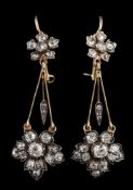 A pair of diamond mounted floral motif drop earrings: each with a rose diamond-set cluster